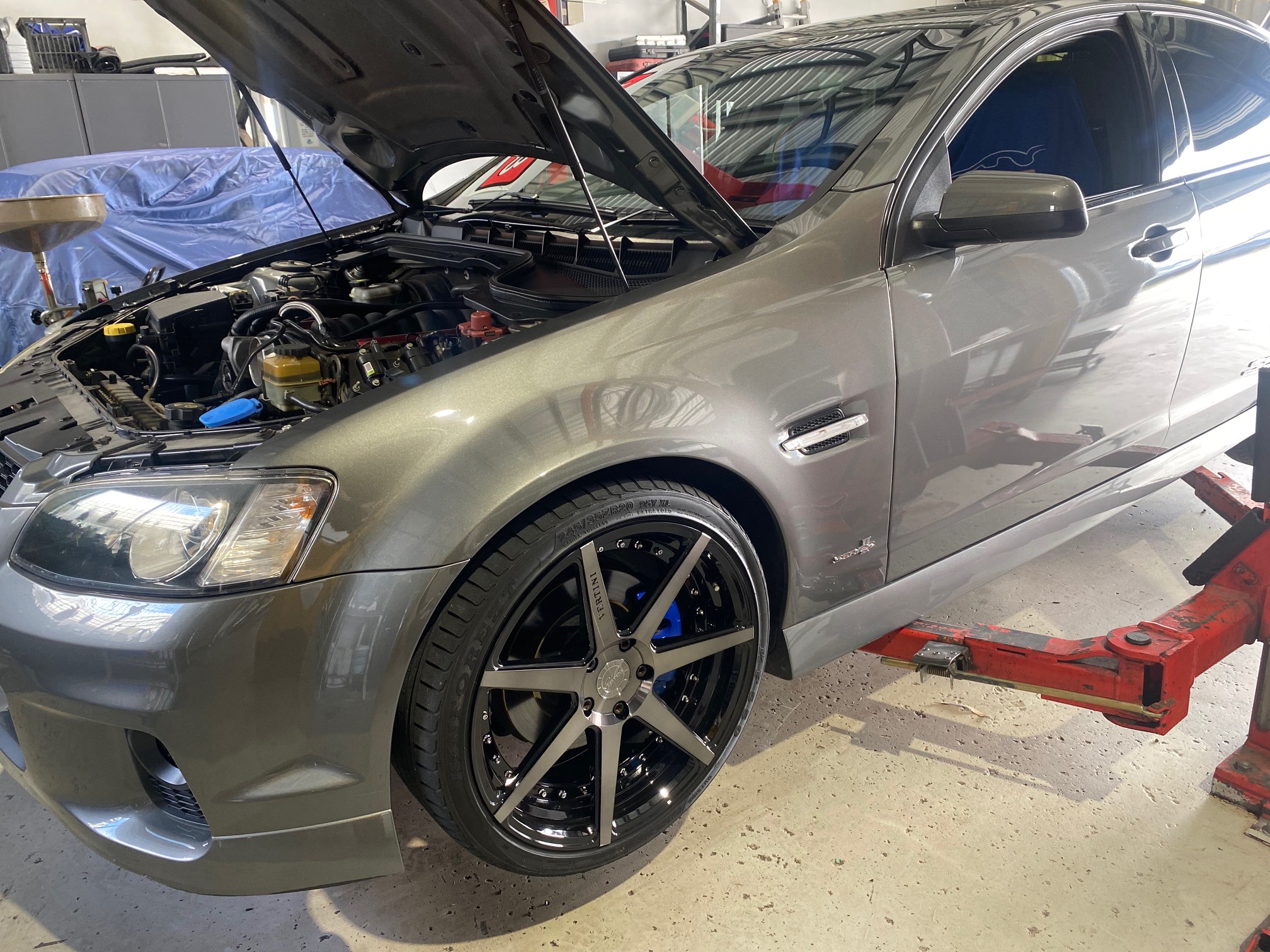 Grey Holden Commodore SS-V with the bonnet up, aftermarket wheels and blue brake calipers